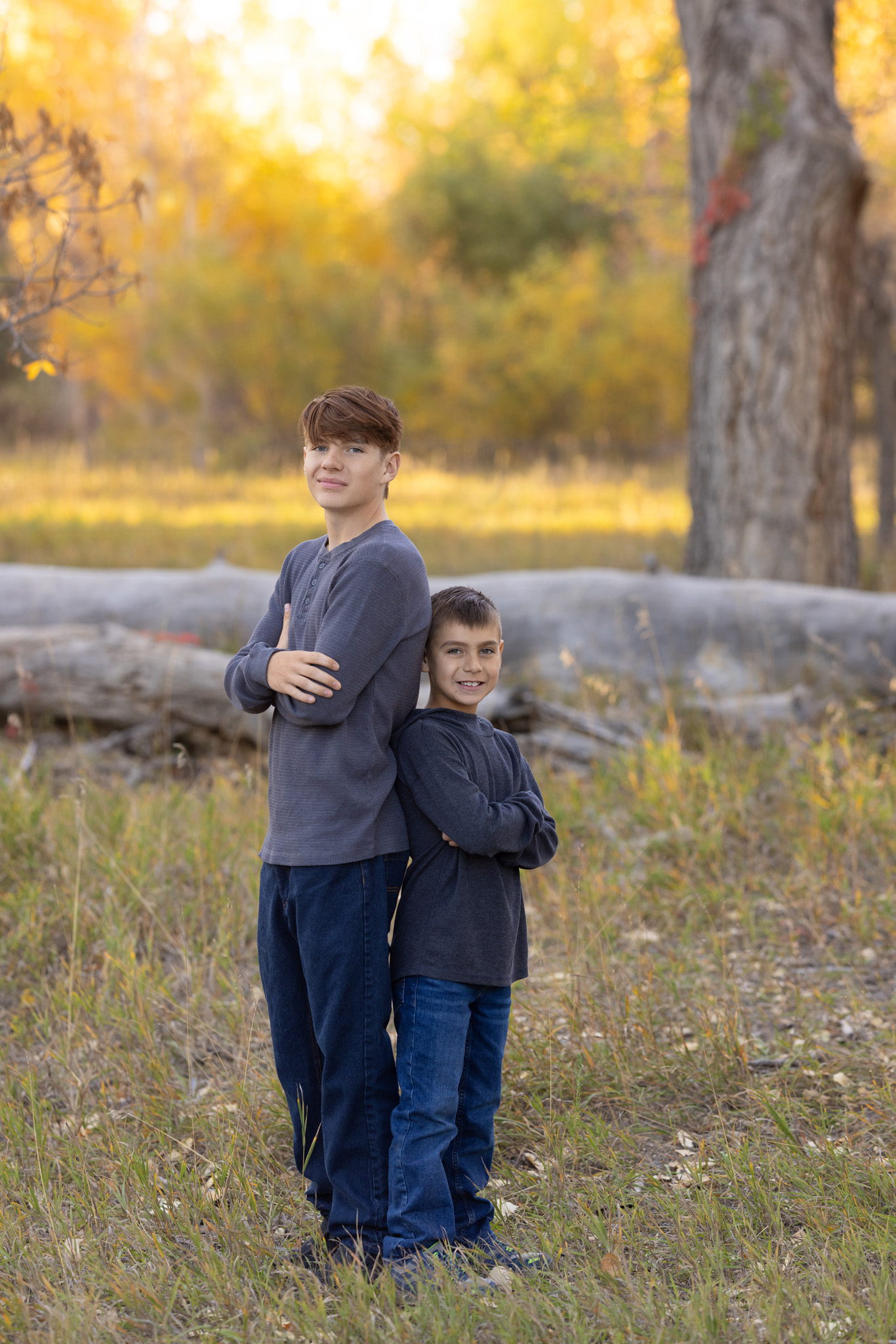 two brothers standing back to back in a field at City Park Pueblo